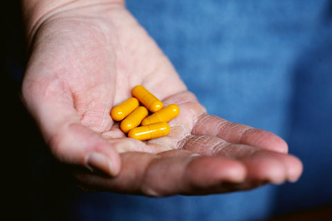Flat lay of berberine capsules with a wooden spoon – berberine supplement in NZ by Nature’s Basket