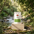 A stand-up pouch of Nature's Basket Amla Powder on a solid beige background. The packaging is white with a green lower section, featuring the brand logo and product name in black text.
