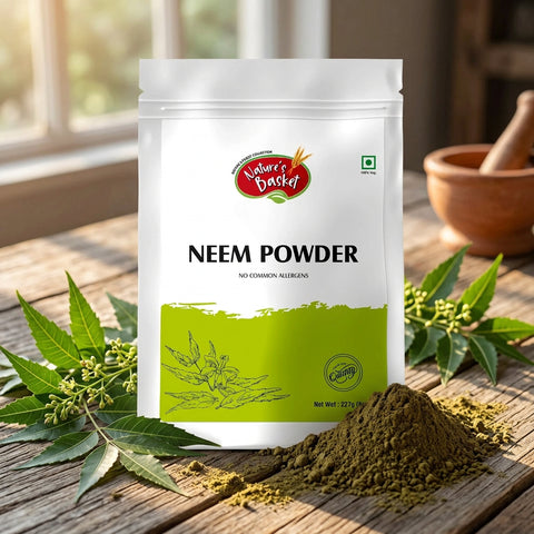 A stand-up pouch of Nature's Basket Neem Powder on a solid beige background. The packaging is white with a bright green lower section, featuring the brand logo and the text 'NEEM POWDER'.